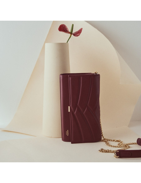 Sac à main en cuir femme Venecia couleur bordeaux, vue frontale en orientation verticale, devant une fleur - MONPIEL Sac à main en cuir femme Venecia couleur bordeaux, vue frontale en orientation verticale, devant une fleur - MONPIEL