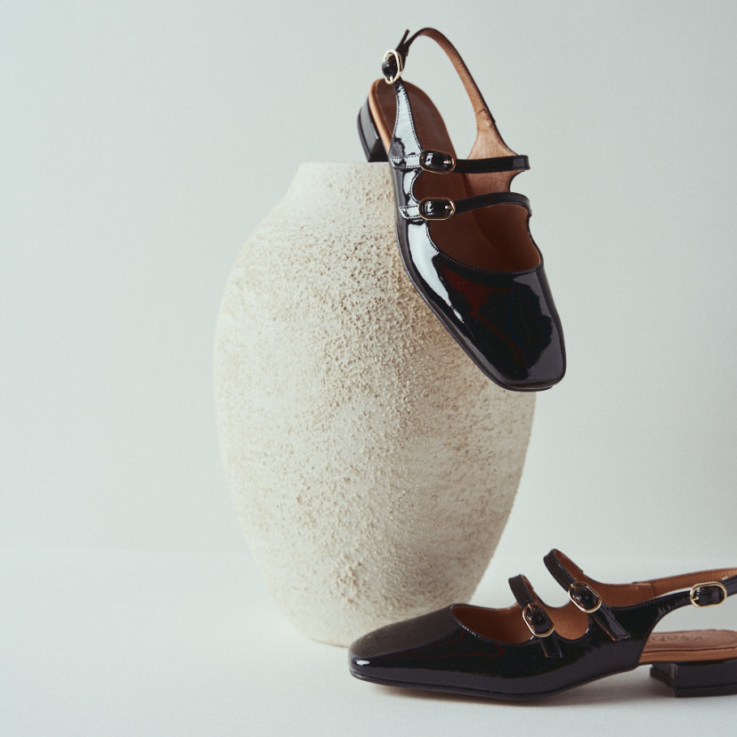 Lolina backless Mary Jane in black with side view and perspective, heel resting on a vase - MONPIEL