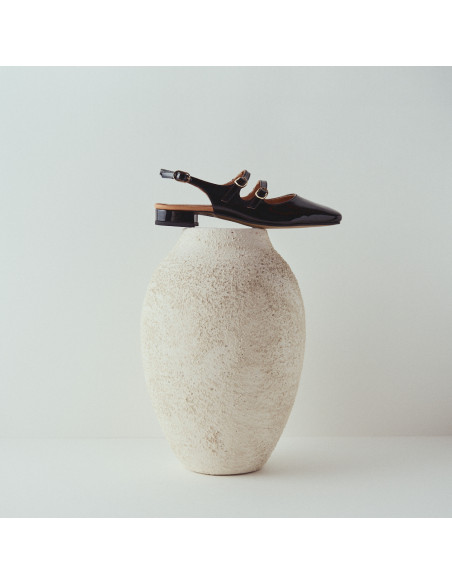 Mary Jane sans talon Lolina en cuir noir, vue de profil au-dessus d'un vase - MONPIEL Mary Jane sans talon Lolina en cuir noir, vue de profil au-dessus d'un vase - MONPIEL