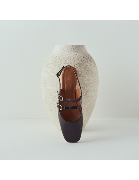 Black backless Lolina Mary Jane, front view, resting on the vase - MONPIEL