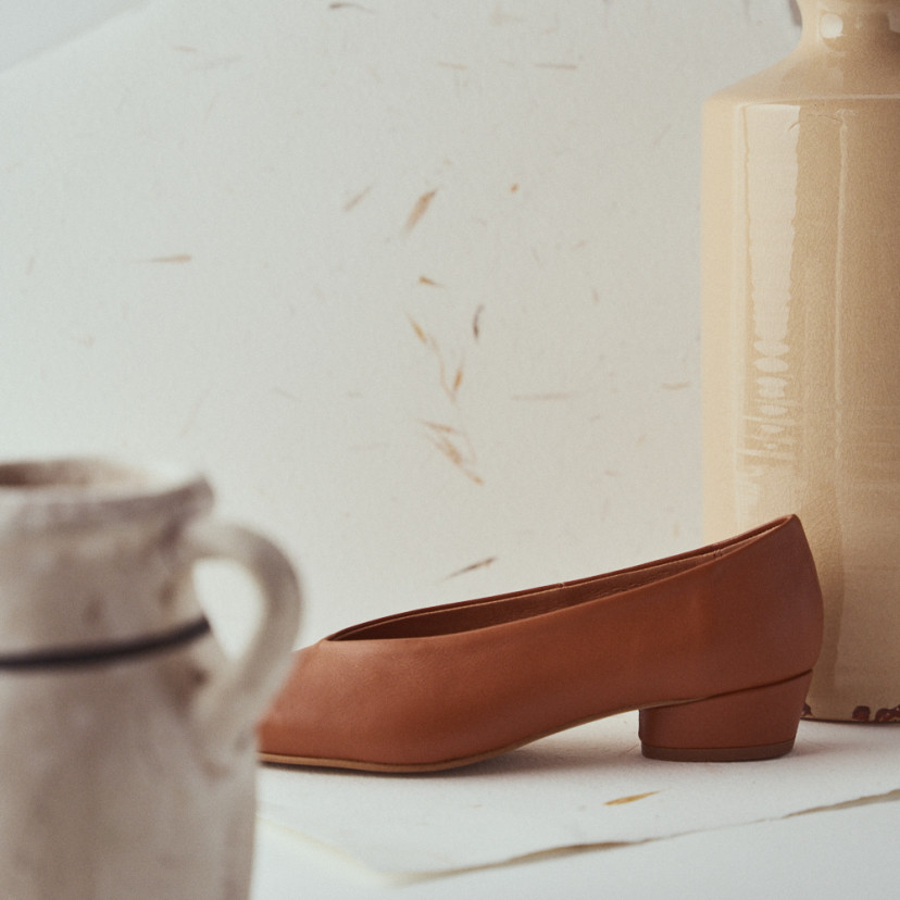 Leather heeled ballerina in leather color with side view and heel detail in front of the vase - MONPIEL