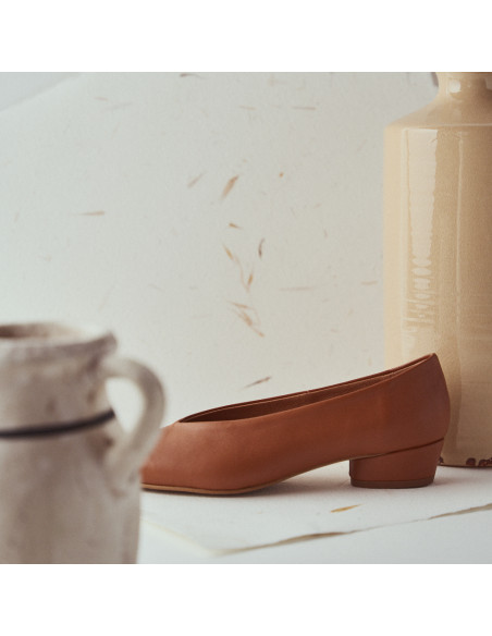 Ballerina con tacco in pelle color cuoio, vista di profilo, dettaglio del tacco davanti a un vaso - MONPIEL Ballerina con tacco in pelle color cuoio, vista di profilo, dettaglio del tacco davanti a un vaso - MONPIEL