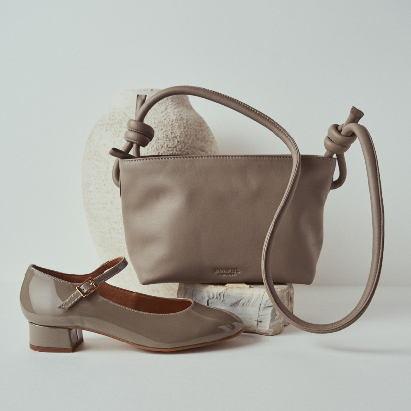 Bolsa pequena de couro com nós na cor taupe, vista frontal e Mary Janes ao lado - MONPIEL