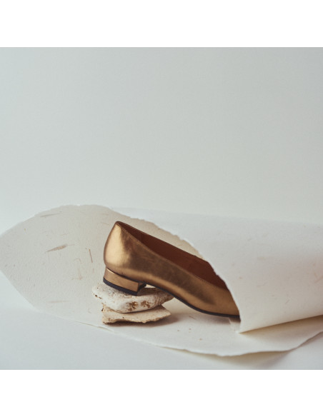 Zapato de mujer punta cuadrada de piel en color ocre detalle primer plano talón apoyado sobre piedras - MONPIEL Zapato de mujer punta cuadrada de piel en color ocre detalle primer plano talón apoyado sobre piedras - MONPIEL