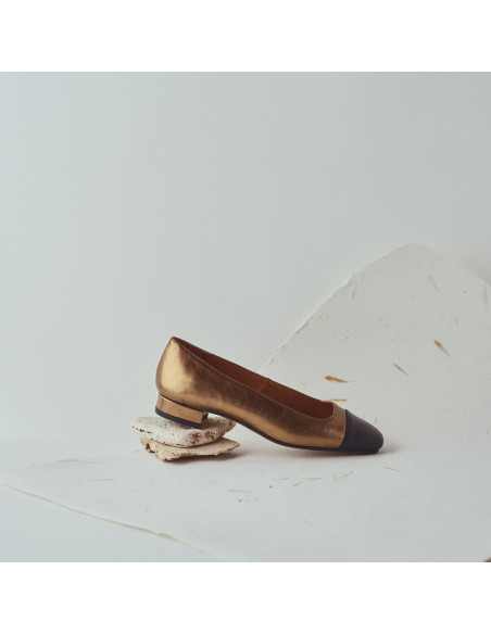 Chaussure pour femme à bout carré en cuir couleur ocre, détail du talon en gros plan reposant sur des pierres - MONPIEL