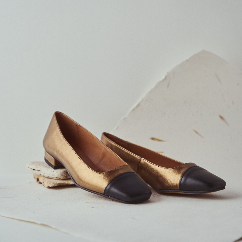Shoe de mulher de ponta quadrada em couro na cor ocre, detalhe de perto do salto apoiado sobre pedras com vista em per - MONPIEL