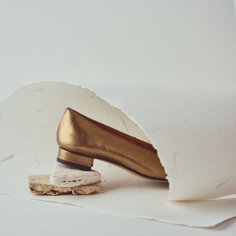 Women's square-toe leather shoe in ochre with close-up heel detail resting on stones - MONPIEL