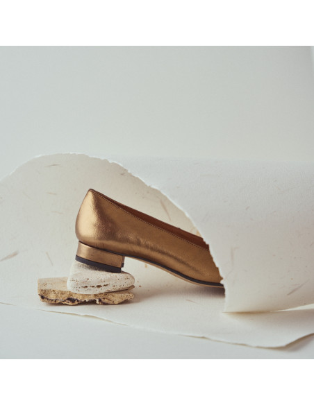 Zapato de mujer punta cuadrada de piel en color ocre detalle primer plano talón apoyado sobre piedras - MONPIEL Zapato de mujer punta cuadrada de piel en color ocre detalle primer plano talón apoyado sobre piedras - MONPIEL