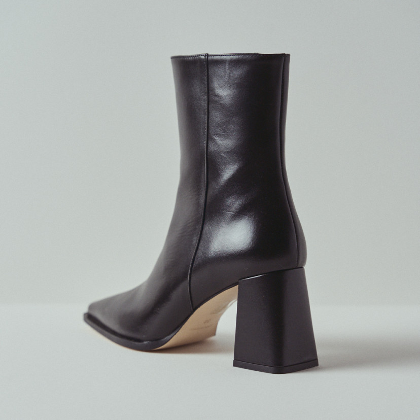 Black leather heeled boot with rear perspective view in close-up - MONPIEL