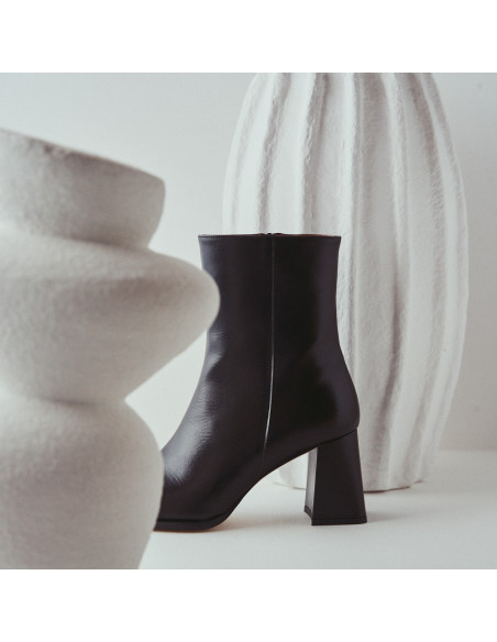 Bottine à talon en cuir noir, vue de profil, placée entre des vases - MONPIEL