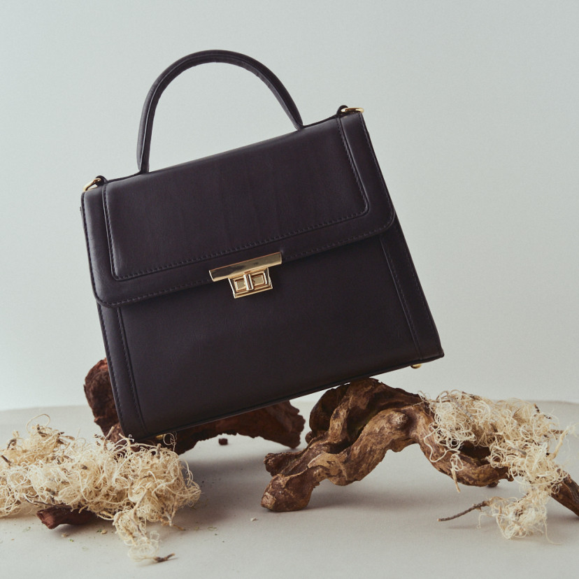 Bolsa de couro feminina 60's na cor preta, apoiada em galhos - MONPIEL