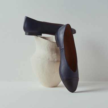 Ameliè flat ballerina with a beige/metallic copper toe cap, profile view, heel resting on decor - MONPIEL 2