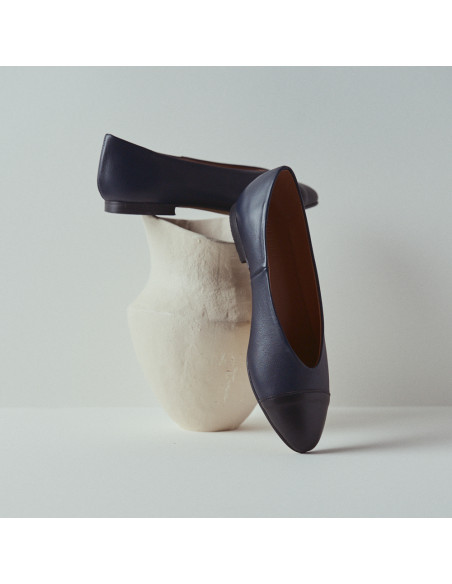 Ameliè flat ballerina with black-navy toe, toe resting in perspective, close-up on a vase - MONPIEL Ameliè flat ballerina with black-navy toe, toe resting in perspective, close-up on a vase - MONPIEL