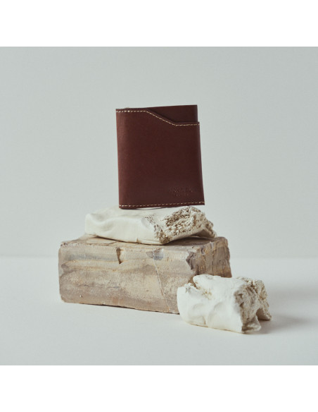 Pocket leather wallet in tan, front view, resting on rocks - MONPIEL Pocket leather wallet in tan, front view, resting on rocks - MONPIEL