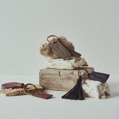 Porte-clés en cuir couleur cuir avec pompon, posé sur des rochers - MONPIEL 2
