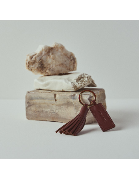 Leather tassel keyring in tan, resting on rocks - MONPIEL Leather tassel keyring in tan, resting on rocks - MONPIEL
