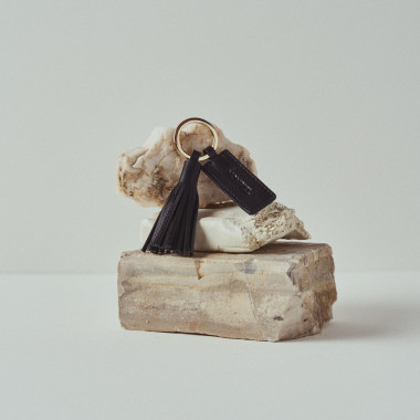 Leather tassel keyring in tan, resting on rocks - MONPIEL 2