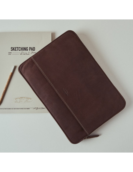 15"-inch brown leather laptop sleeve, tilted, top view, on a table - MONPIEL
