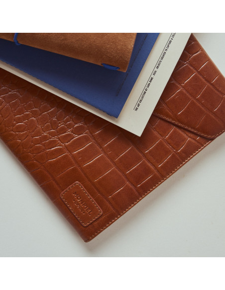 Capa de notebook de couro Elegance Coco na cor couro com livros por cima - MONPIEL