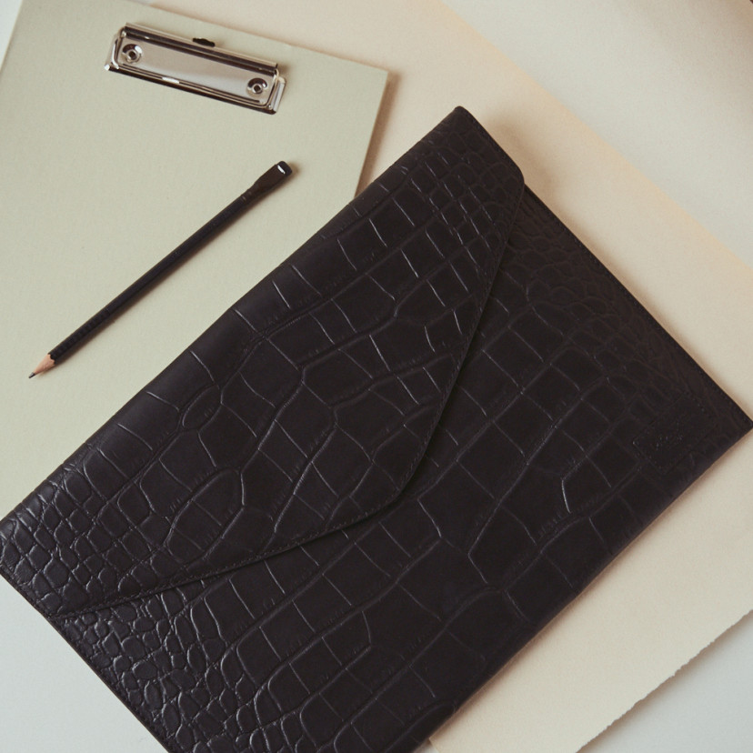 Elegance coco leather laptop sleeve in black with top view resting on the table - MONPIEL