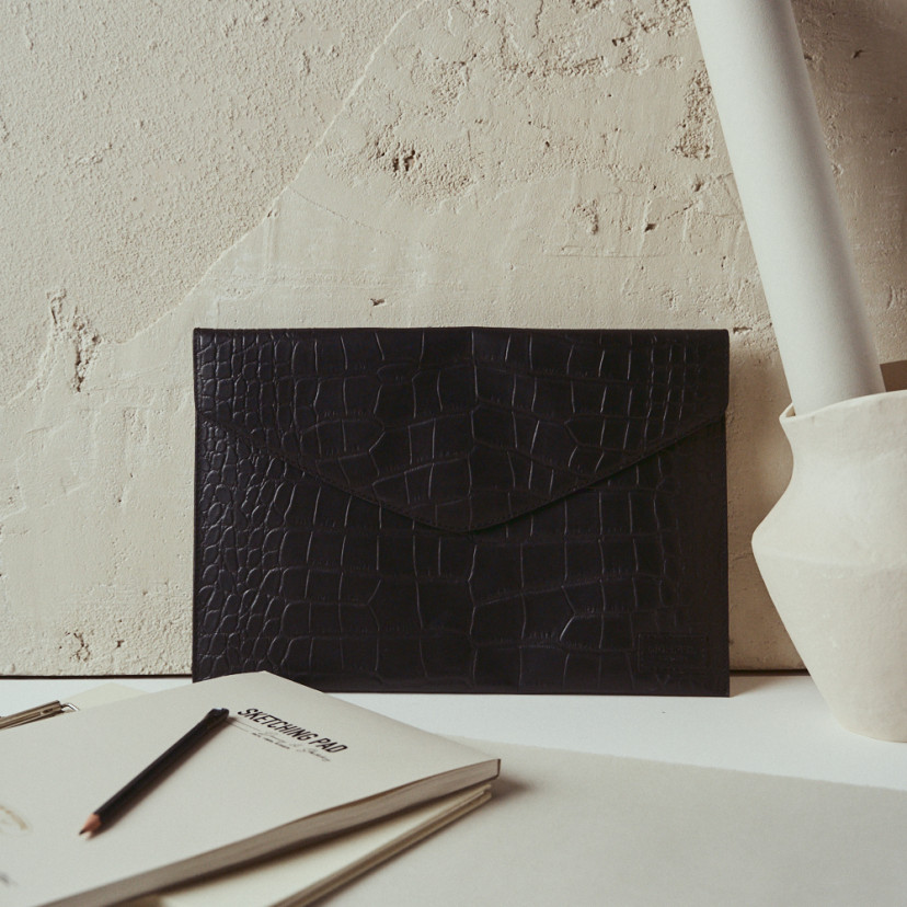 Elegance coco leather laptop sleeve in black with front view resting on the wall - MONPIEL