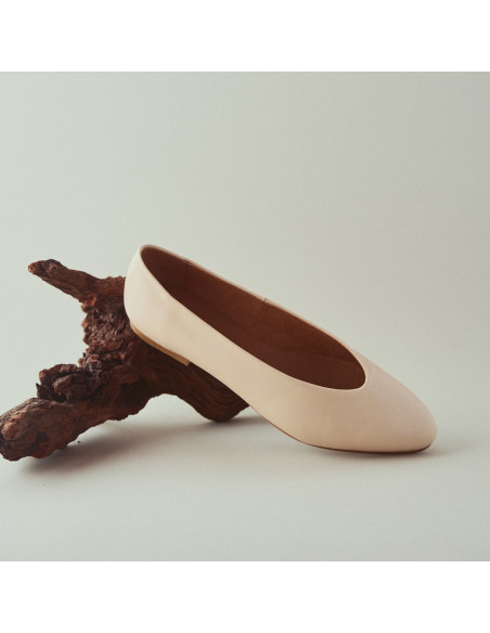 Beige flat ballet shoe, front and perspective view, resting on a branch with a white background - MONPIEL