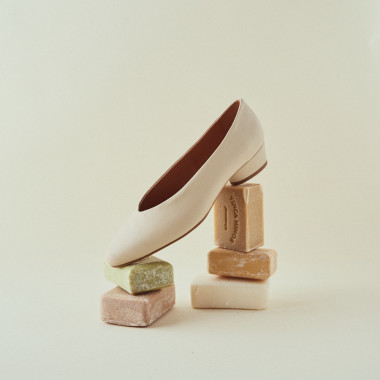 Heeled ballet flat in tan, resting on grey trays, side perspective view - MONPIEL 2