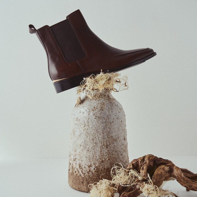 Luisa brown leather Chelsea boot with side view on top of a vase - MONPIEL