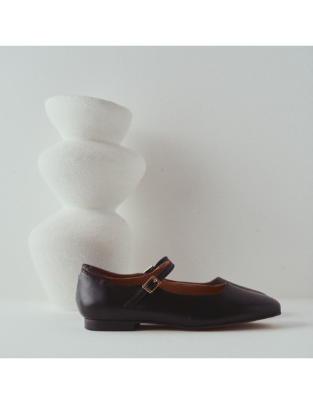 Carlota-Mary-Jane-Schuh mit Riemen in Schwarz, Profilansicht, vor einem Vase, Nahaufnahme - MONPIEL