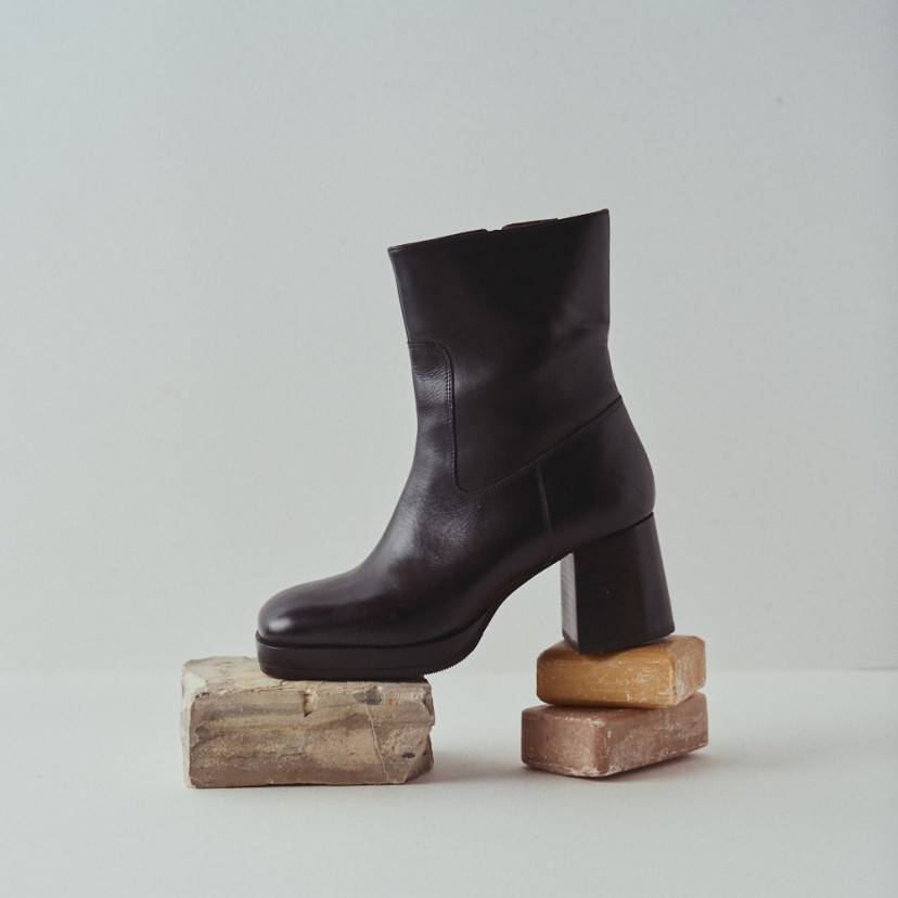 Claudia platform boot in black with side view in close-up resting on soap and rock - MONPIEL