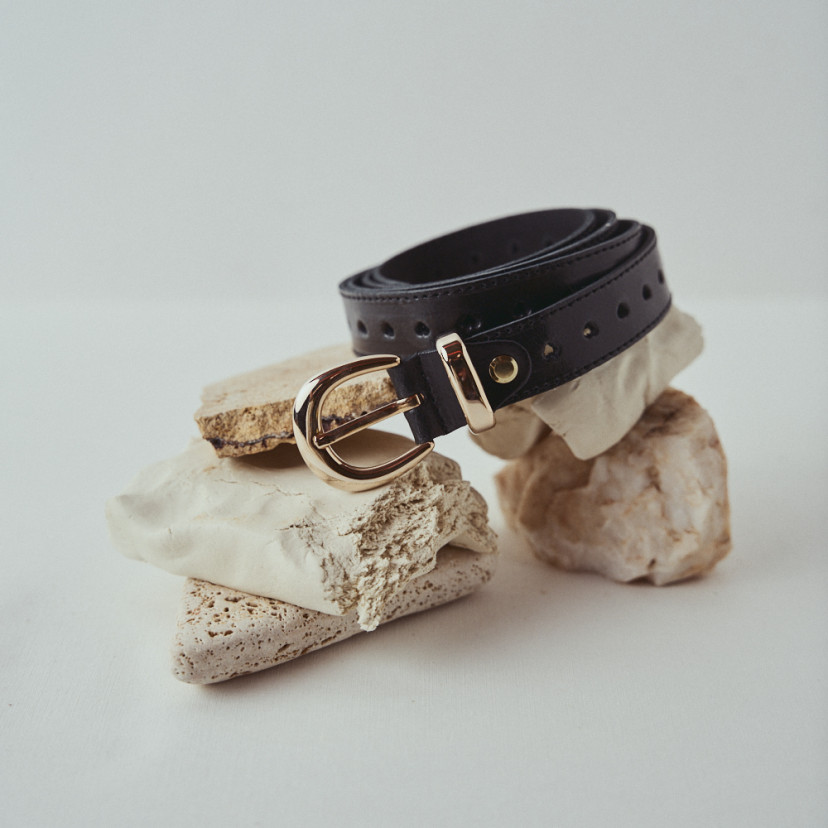 Black leather heart belt coiled on a stone - MONPIEL