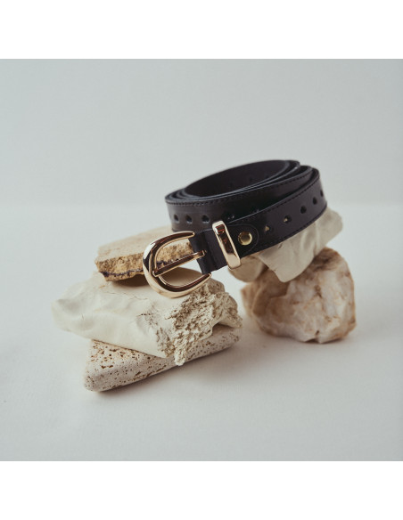 Black leather heart-patterned belt, coiled on a stone - MONPIEL Black leather heart-patterned belt, coiled on a stone - MONPIEL