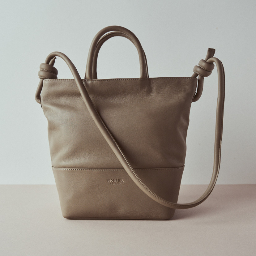 Bolsa grande de couro com nós na cor taupe, vista frontal e detalhe da alça com fundo de parede - MONPIEL