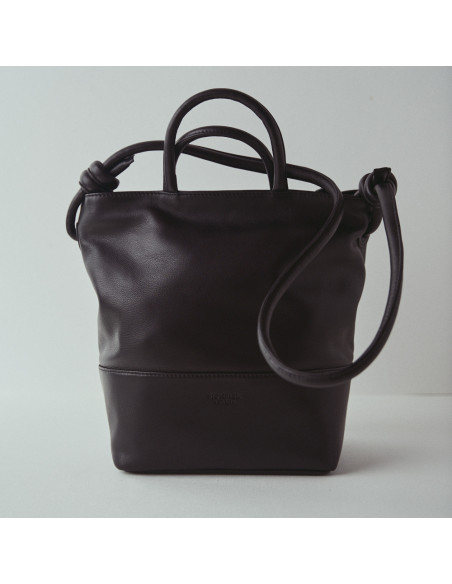 Bolsa grande de couro com nós na cor preta, vista frontal com fundo de parede - MONPIEL Bolsa grande de couro com nós na cor preta, vista frontal com fundo de parede - MONPIEL