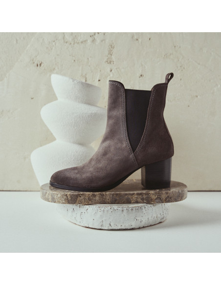 Marcela suede leather ankle boot in gray, profile view, resting on marble - MONPIEL Marcela suede leather ankle boot in gray, profile view, resting on marble - MONPIEL