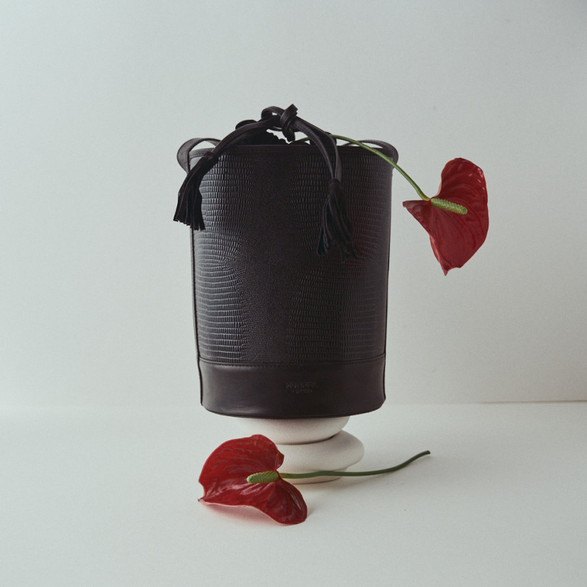 Bolsa redonda em formato de balde de couro com padrão de serpente preta, vista frontal, detalhe de flores, fundo branc - MONPIEL