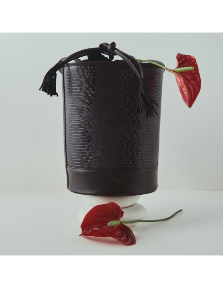 Bolso redondo en forma de cubo de piel en color serpiente negro con vista frontal apoyado con detalle flor - MONPIEL