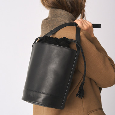 Round cube-shaped leather bag in black with front view, wall background - MONPIEL 2