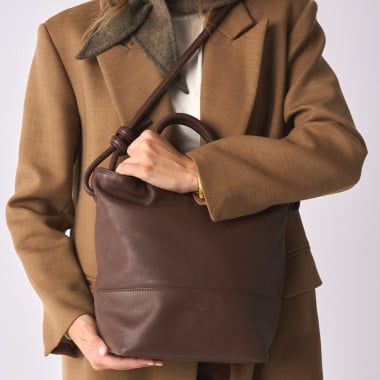 Large leather knot handbag in leather color with front view, held by the short handle in the hand - MONPIEL 2