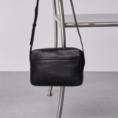 Bolso bandolera básico color negro en plano frontal colgado en una silla - MONPIEL