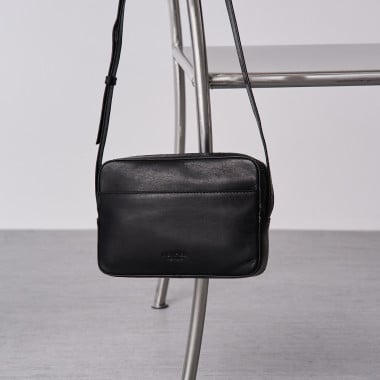 Borsa a tracolla basic color nero, piano frontale appesa a una sedia - MONPIEL