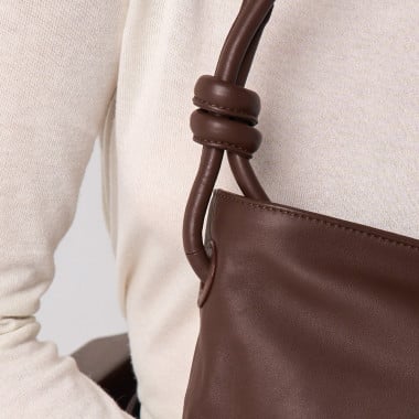 Bolso nudos pequeño de piel en color topo con vista frontal cogido con la mano por el asa - MONPIEL 2