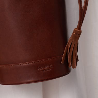 Bolso redondo cubo pequeño de piel en color negro con vista frontal apoyado sobre libro - MONPIEL 2
