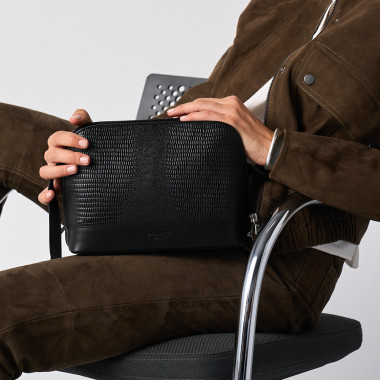 Medium leather bag in tan, front view, tilted, resting on a vase - MONPIEL 2