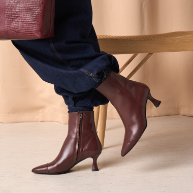 Jimena pointed-toe leather boot in black with side view resting on a rock in close-up - MONPIEL 2