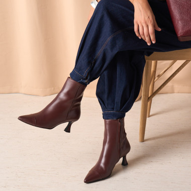 Jimena pointed-toe leather boot in black with side view resting on a rock in close-up - MONPIEL 2