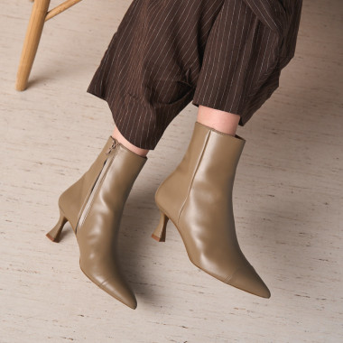 Jimena pointed-toe leather boot in black with side view resting on a rock in close-up - MONPIEL 2