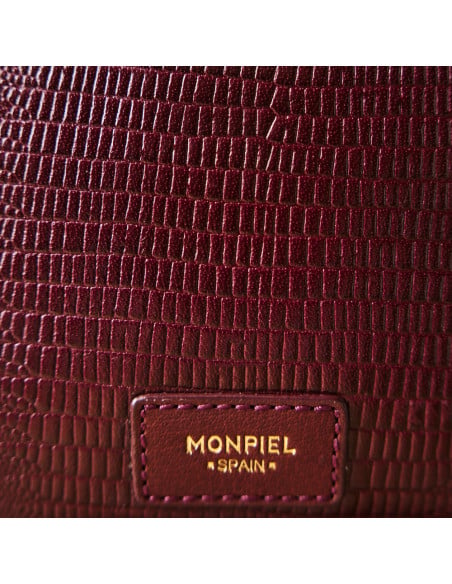 Bolsa em pele de serpente e camurça bordô em plano de detalhe sobre a pele e o patch com logótipo - MONPIEL