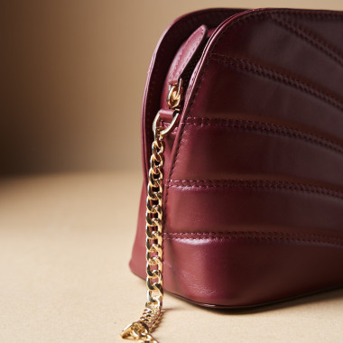 Sac matelassé en cuir couleur cuir avec chaîne dorée, à côté de savons - MONPIEL 2