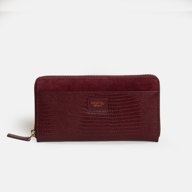 Women’s leather wallet with zipper in leather color, perspective view resting on a vase - MONPIEL 2